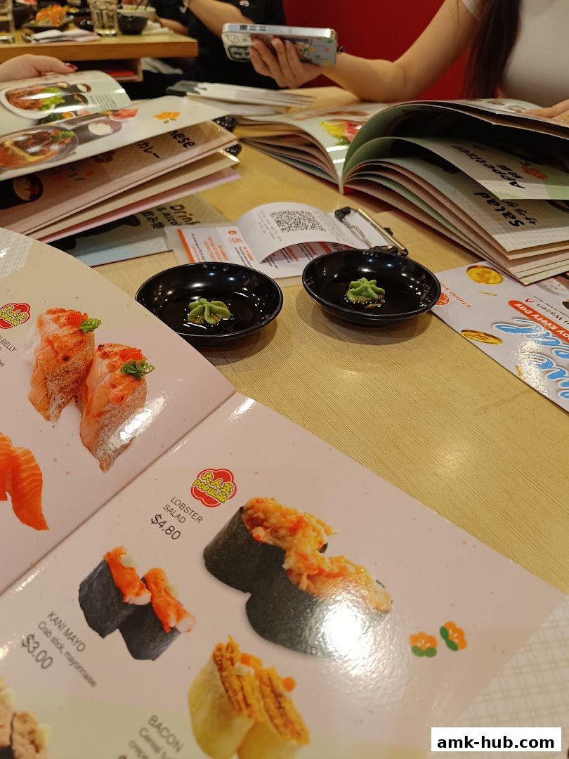 A close-up of a sushi menu with various rolls and appetizers displayed.