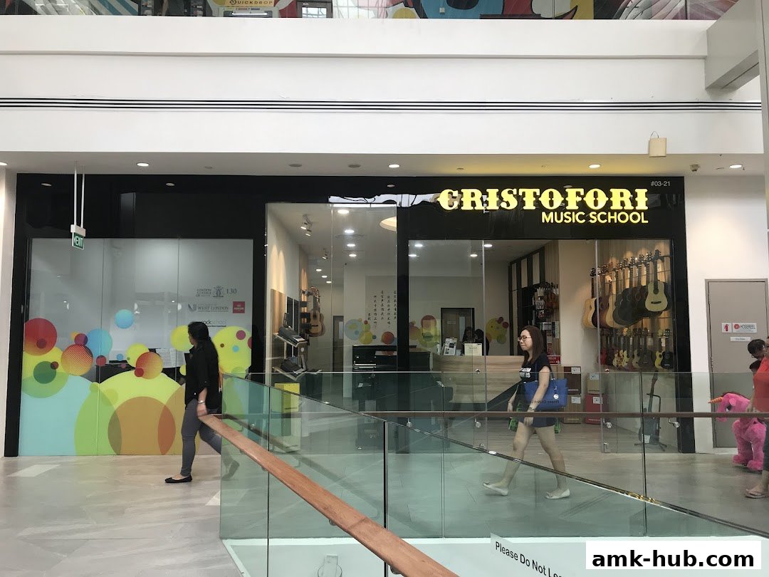 Cristofori Music School storefront with guitars displayed inside and people walking by.
