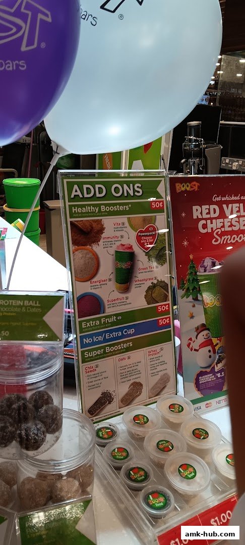 A menu board displaying Boost Juice add-ons and boosters, with a special offer for Red Velvet Cheese Smoothie.