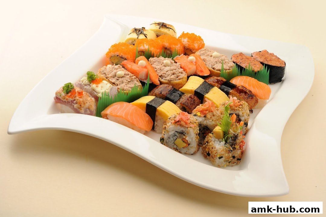 A large platter of assorted sushi and maki rolls, beautifully arranged on a white plate.