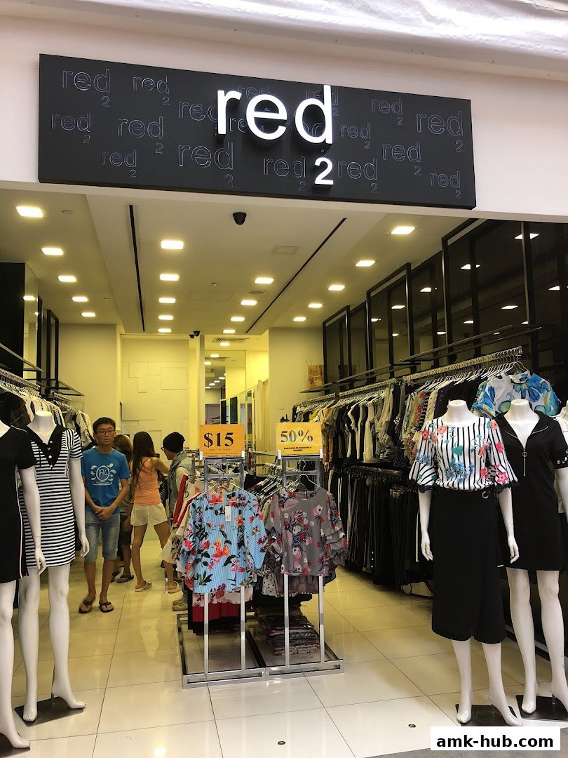 A fashion store entrance with mannequins and clothing displays, featuring a prominent "red 2" sign.