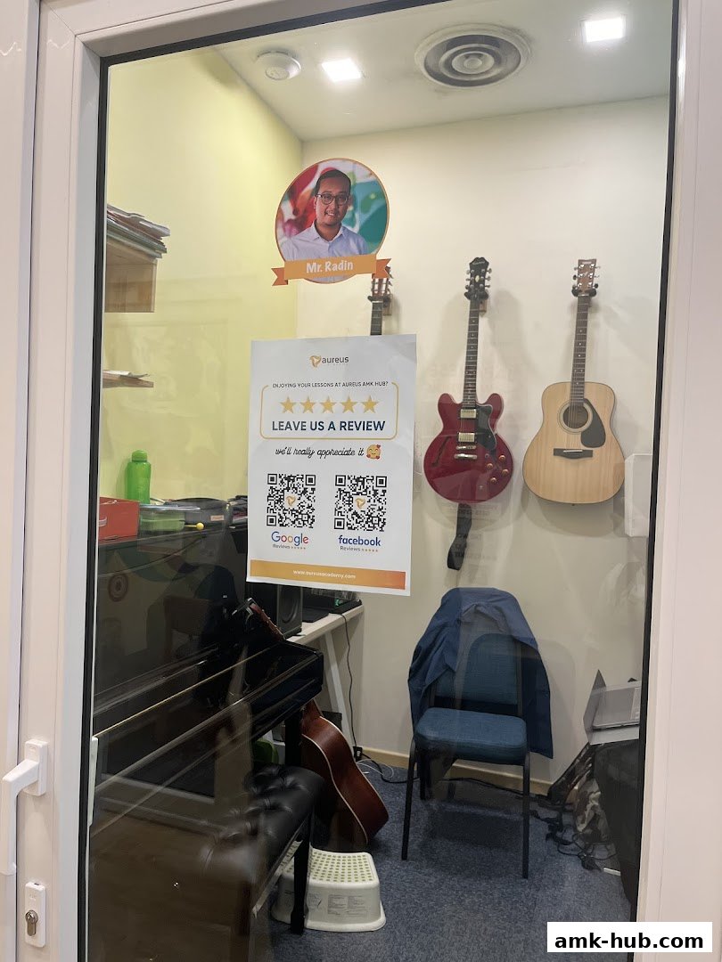Interior of Aureus Academy with guitars, a piano, and a review poster.