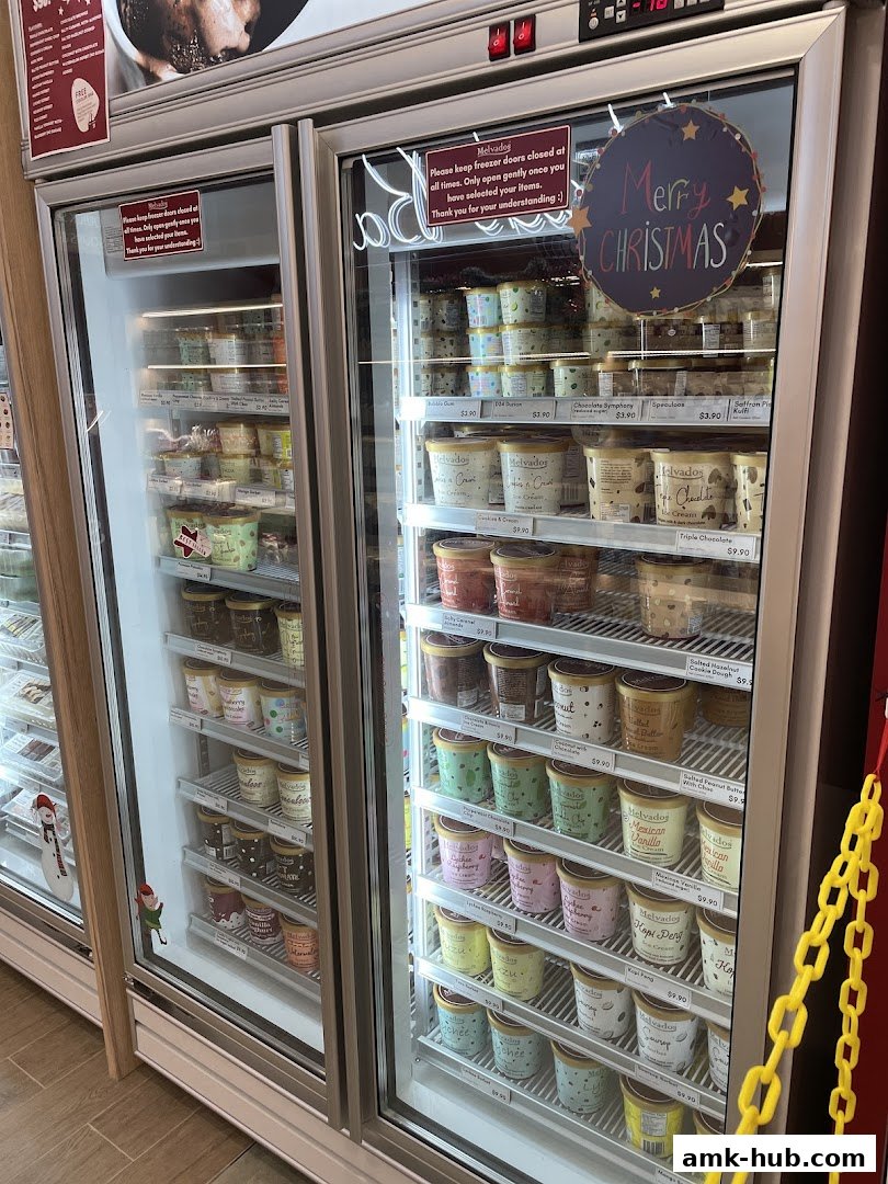 Freezer display of various Melvados ice cream flavors with prices and Christmas decorations.