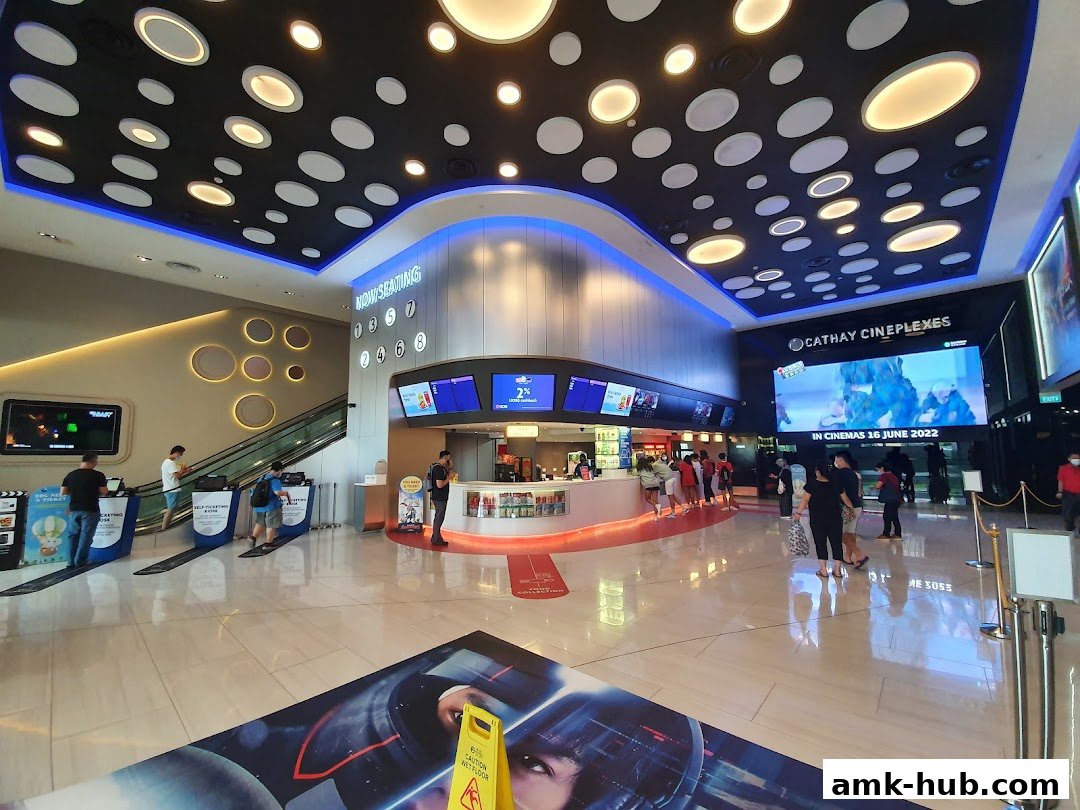 Interior view of Cathay Cineplexes lobby with ticket counters and movie posters.