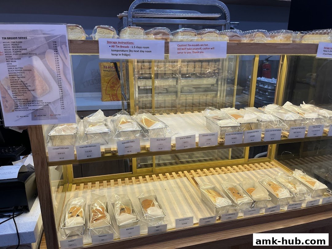 A display case filled with various baked goods, with a menu listing tin breads and their prices.