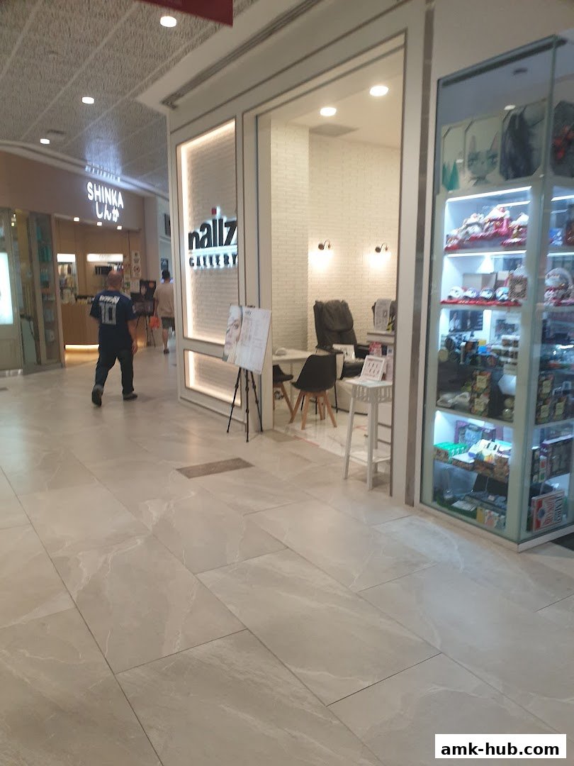 The exterior of Nailz Gallery, a nail salon, with a display stand outside.