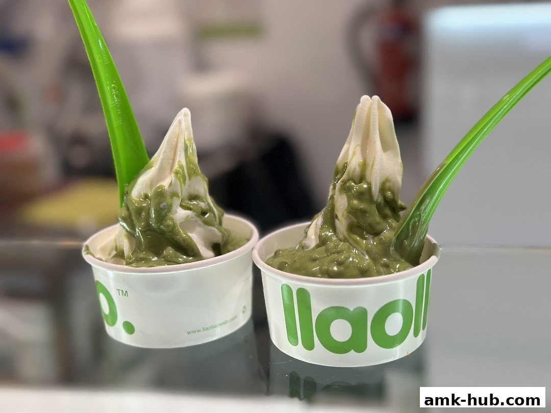 Two cups of frozen yogurt with green sauce and green spoons.