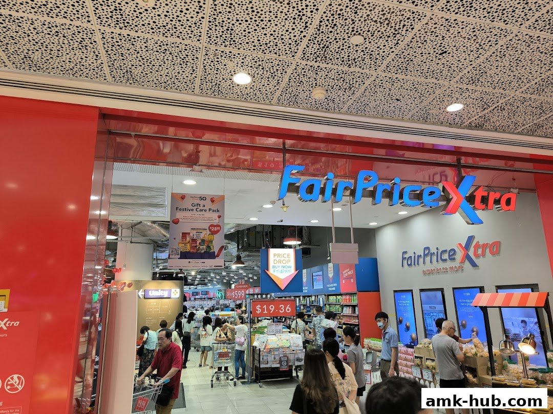 The entrance of a FairPrice Xtra supermarket with shoppers and promotional displays.