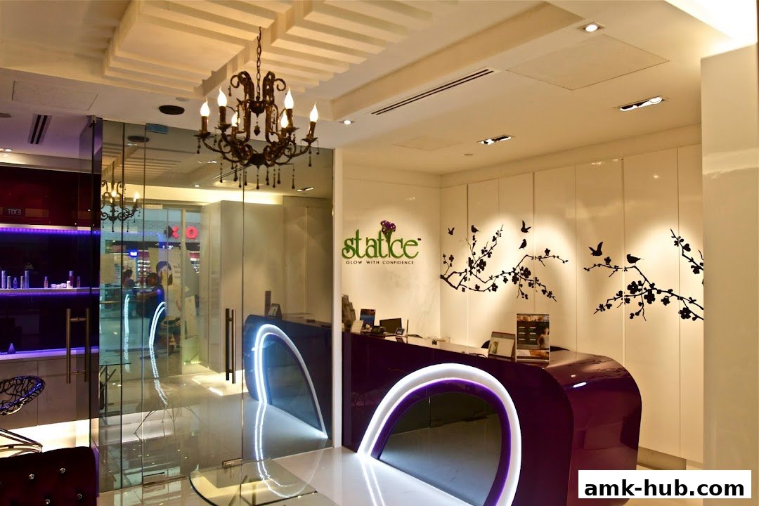 The reception area of Statice Spa features a modern purple reception desk with neon accents and elegant decor.