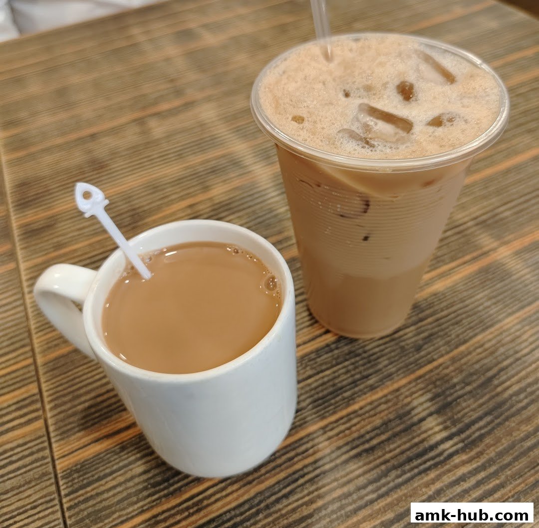 Two refreshing beverages, one in a white mug and another in a clear plastic cup, sit on a wooden table.