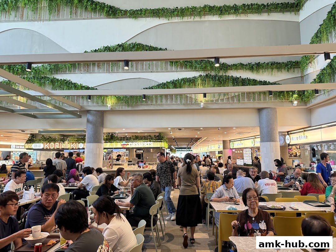 A busy food court with many people dining and ordering food.