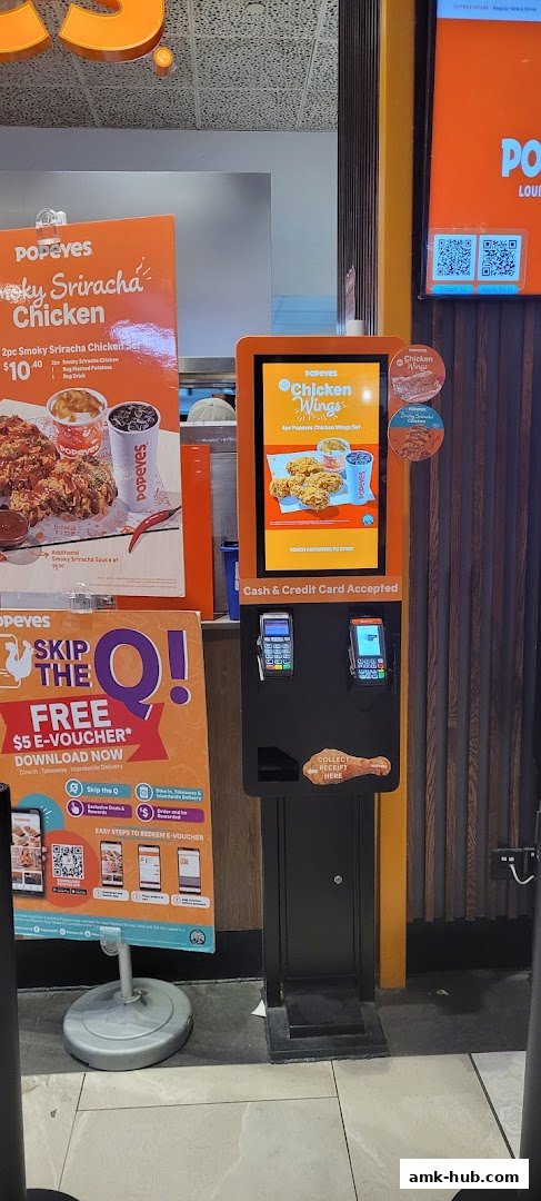Popeyes restaurant with a self-order kiosk and promotional signage for chicken.