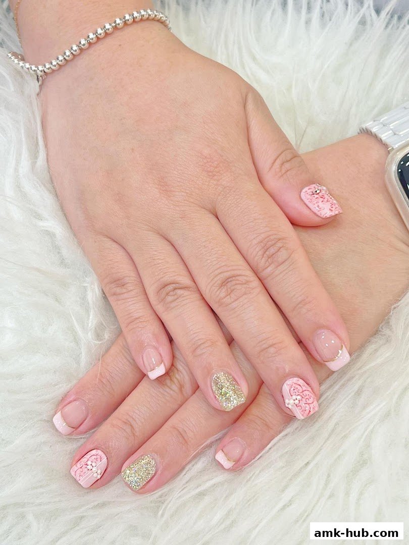 Close-up of hands with beautifully decorated pink and gold nails.