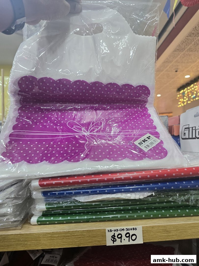 A hand holds a plastic bag with polka dot designs, stacked with colorful polka dot rolls.