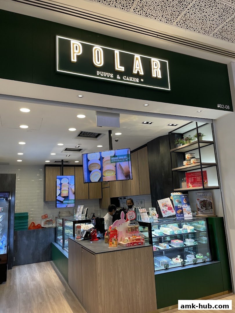 The entrance of Polar Puffs & Cakes shop, showcasing a display of cakes and pastries.