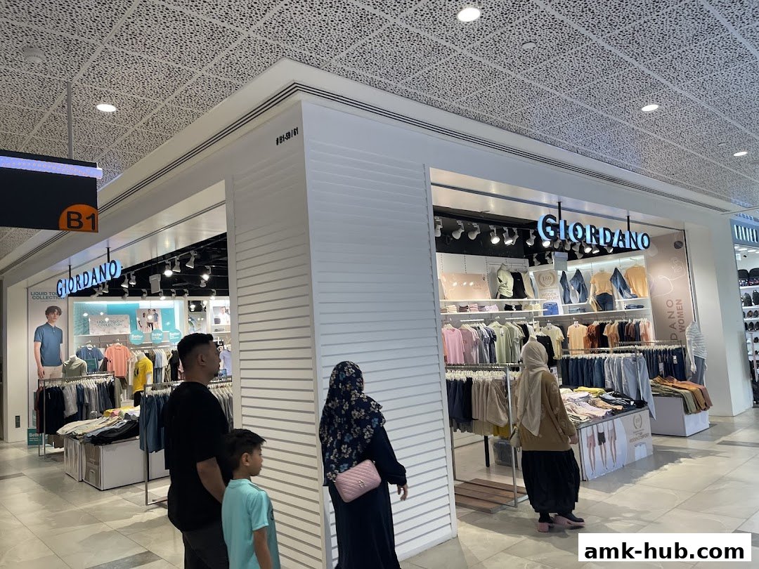 A Giordano clothing store with racks of colorful shirts and jeans, and mannequins displaying outfits.