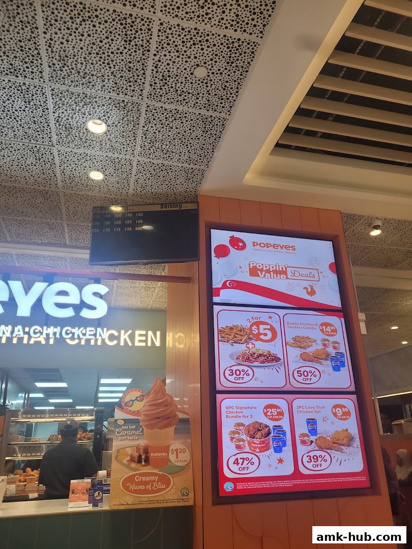 Popeyes restaurant with digital menu boards displaying value deals and a soft serve ice cream.