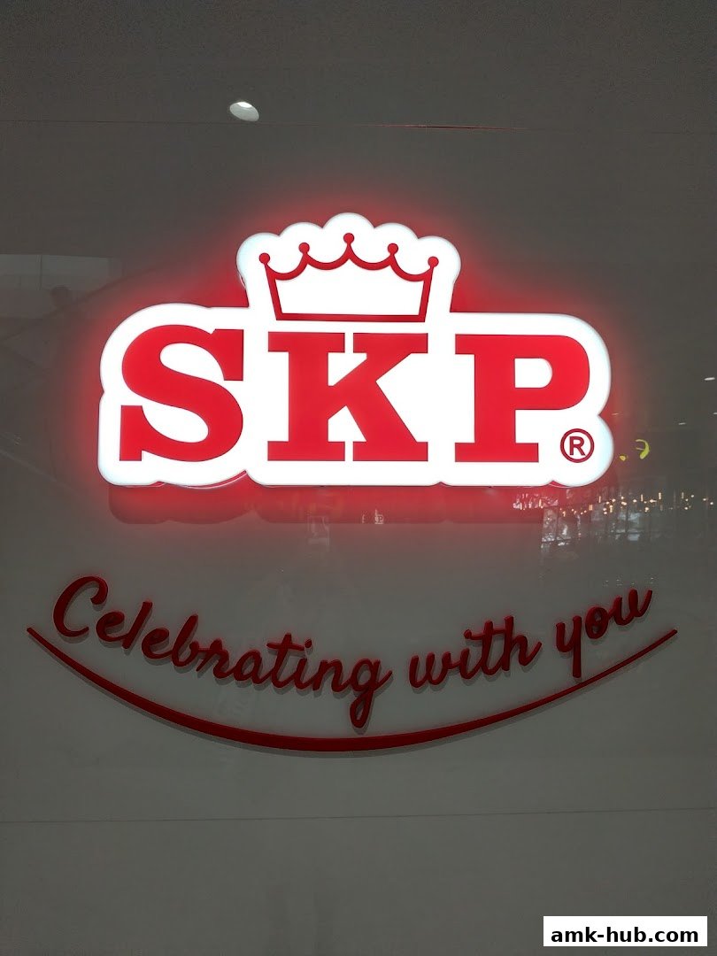 A neon sign for SKP with the tagline 'Celebrating with you'.