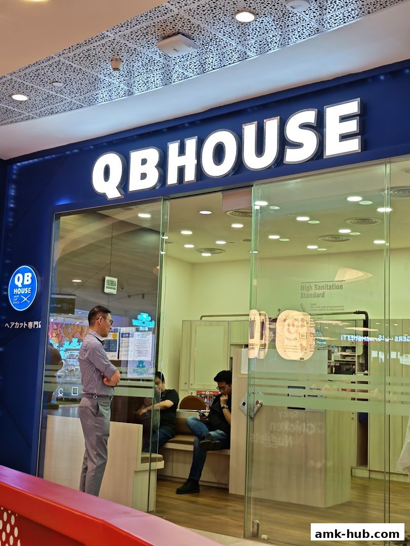 QB House hair salon entrance with staff and customers waiting inside.