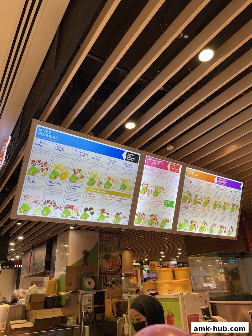 A brightly lit menu board displaying various fruit juice and smoothie options at Boost Juice.