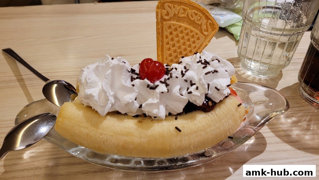 A delicious Swensens banana split dessert with whipped cream, cherry, and a waffle crisp.