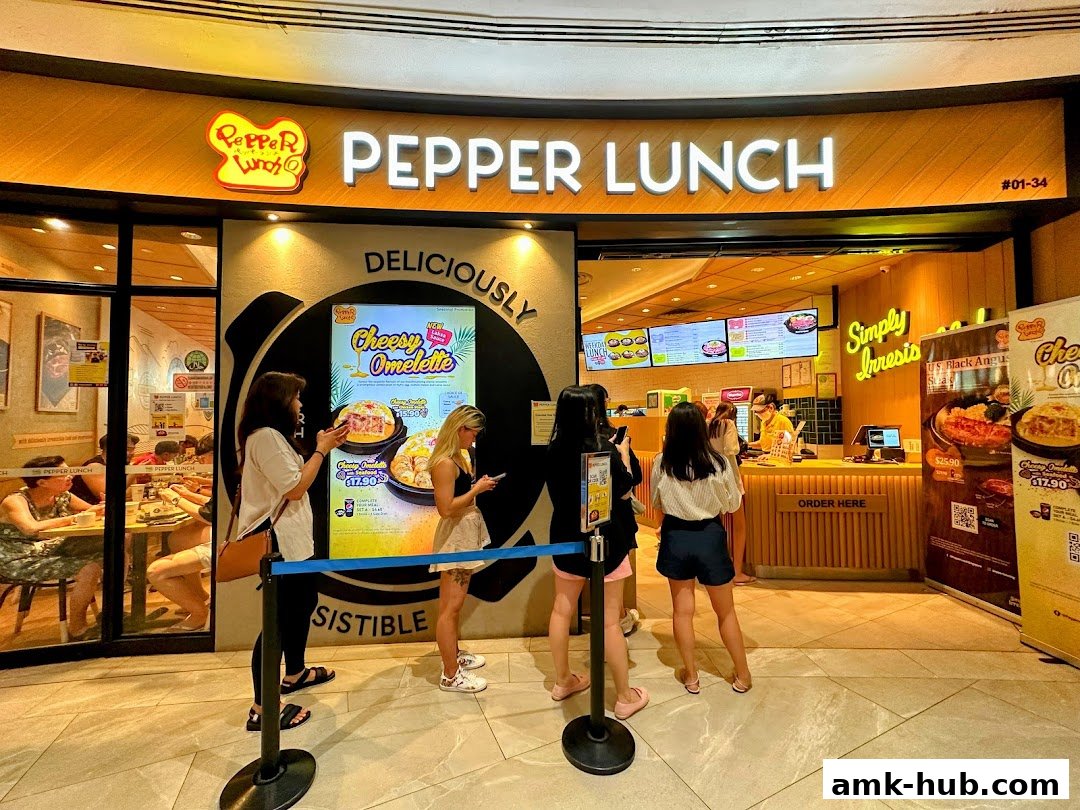 Pepper Lunch restaurant storefront with customers queuing and promotional posters.