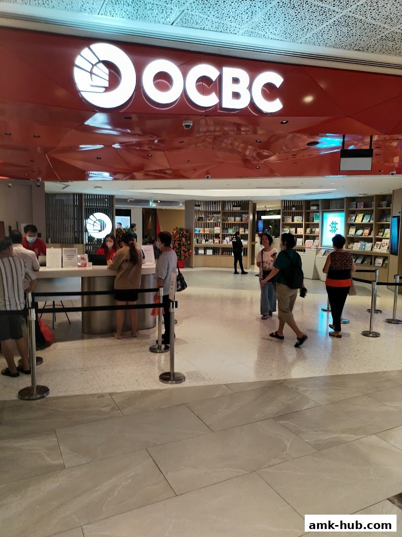 The entrance of an OCBC Bank branch with customers and staff visible.