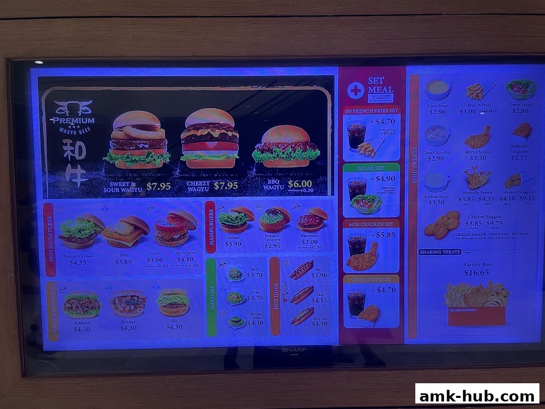 A digital menu board displaying various burgers, sides, and set meals from MOS Burger.