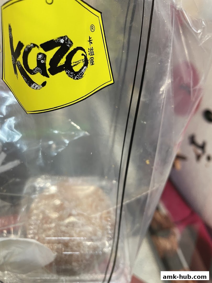 A close-up of a Kazo branded bag containing a pastry.