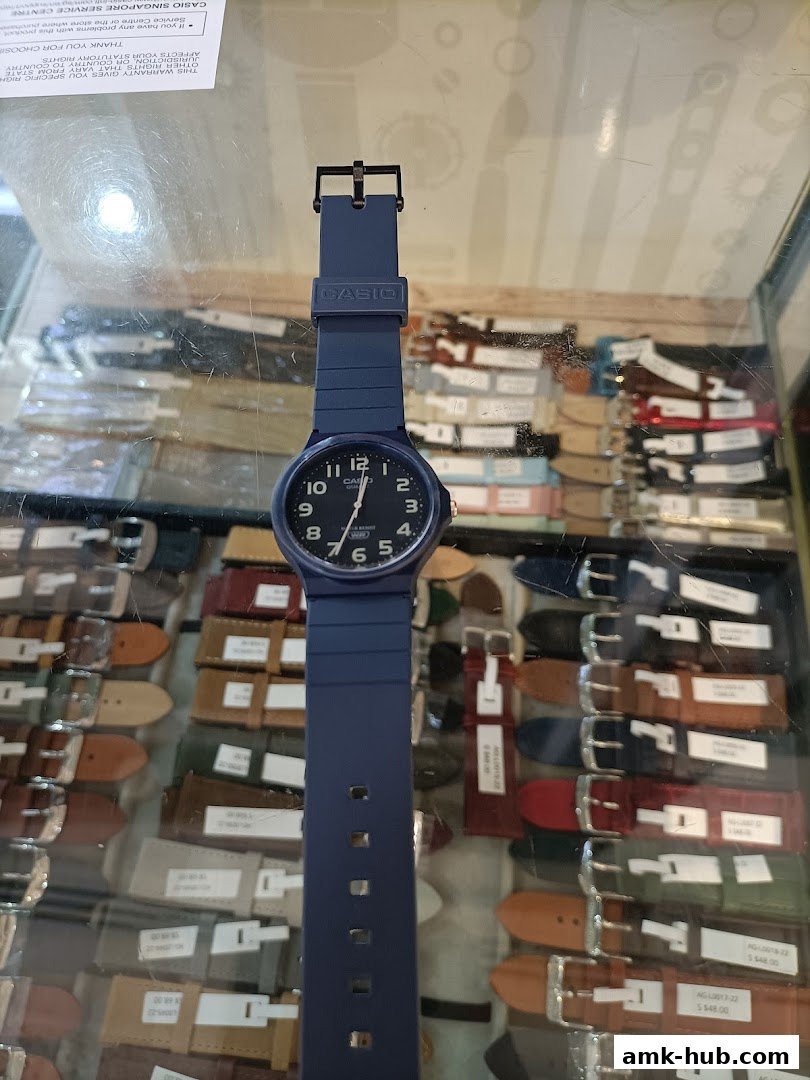 A blue Casio watch is displayed in front of a collection of watch straps.