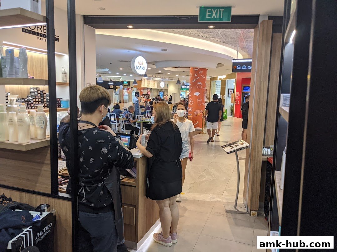 Hair salon interior with staff and customers, showcasing hair products and a reception area.