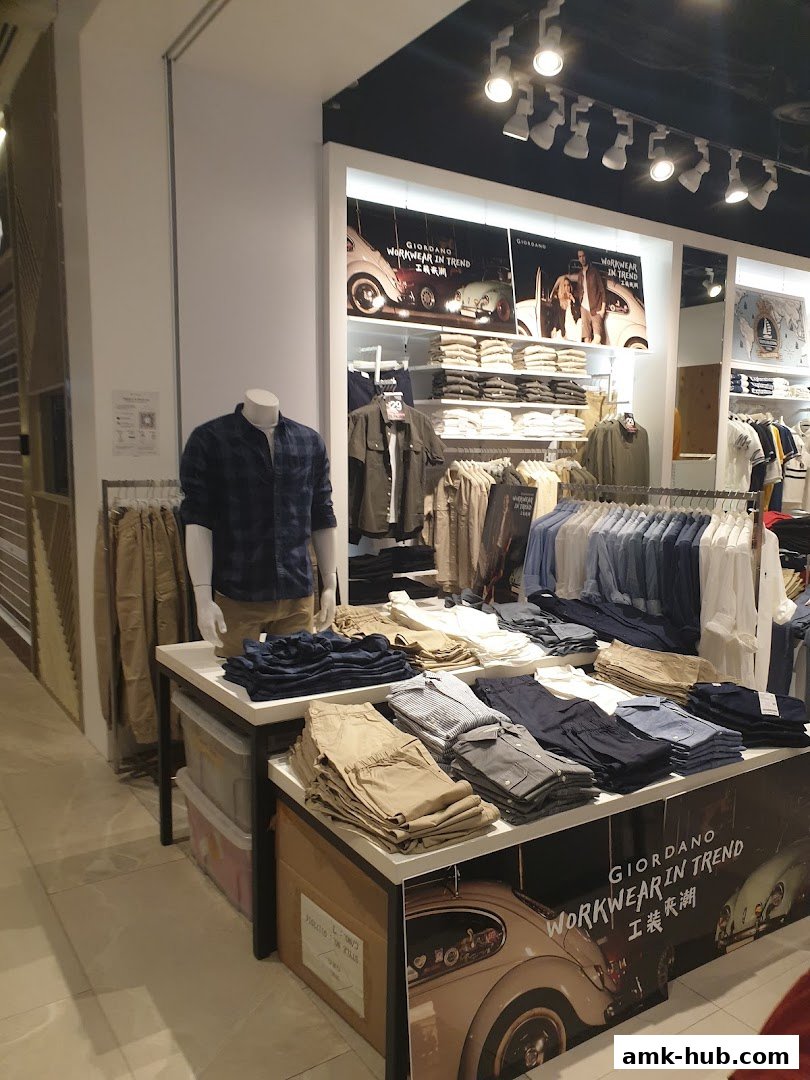 A display of men's casual wear, including shirts and pants, at a Giordano store.