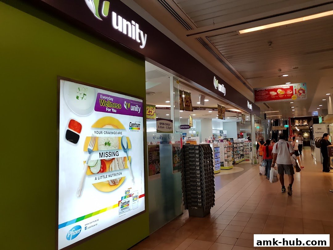 The exterior of a Unity pharmacy and wellness store with a large advertisement for Centrum.