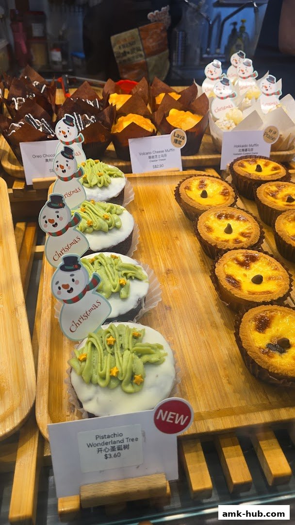 A display of festive Christmas-themed pastries, including cupcakes and tarts, at a bakery.