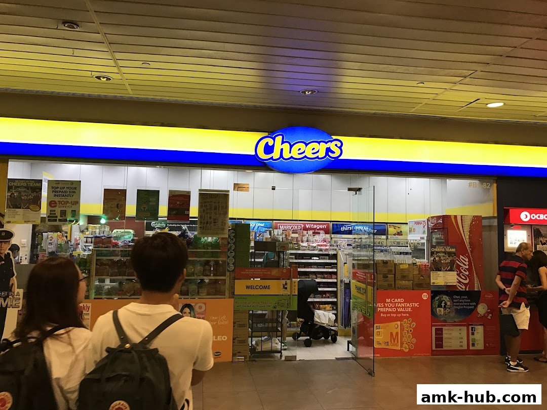 The entrance of a Cheers convenience store with promotional displays and customers.