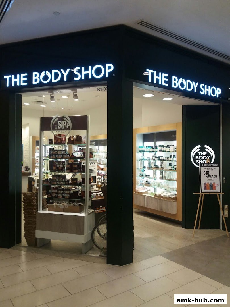 The Body Shop storefront with illuminated signage and displays of beauty products.