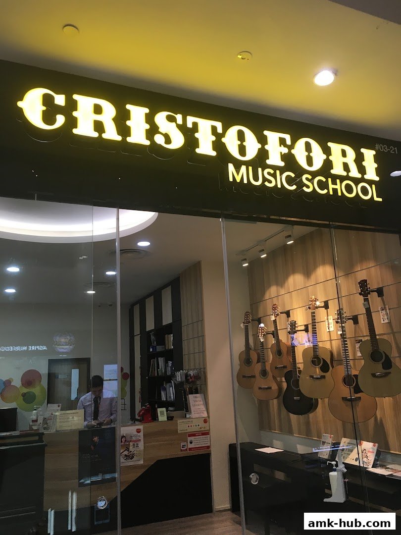 Cristofori Music School entrance with guitars displayed and a receptionist inside.