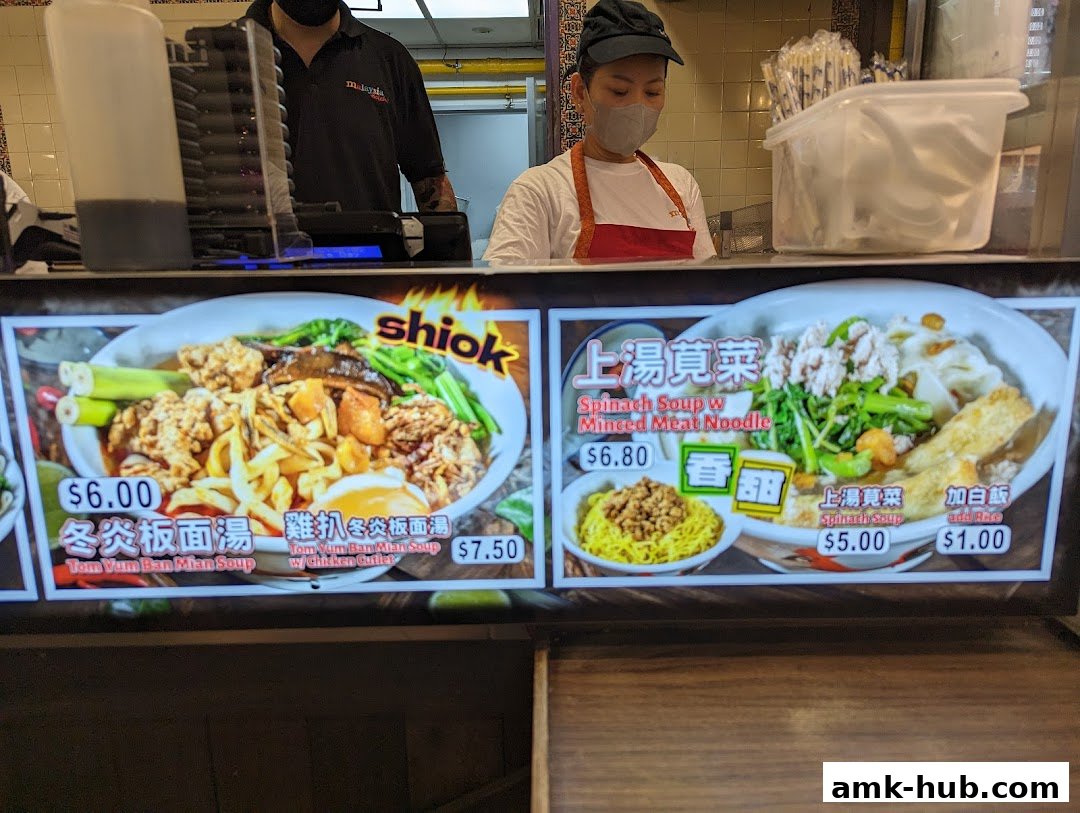 A display of two Malaysian noodle dishes with prices and descriptions.