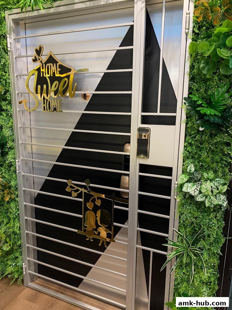 A modern metal gate with decorative 'Home Sweet Home' and couple swing motifs, flanked by lush greenery.