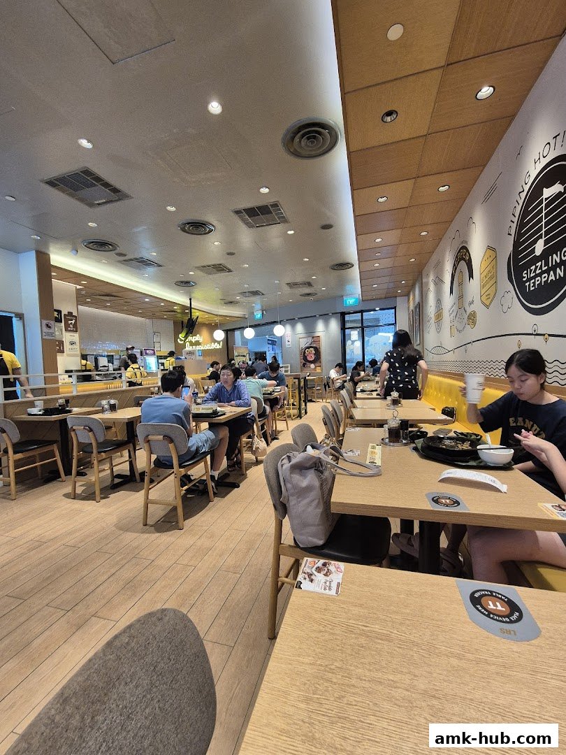 Interior view of a busy Pepper Lunch restaurant with diners enjoying their meals.