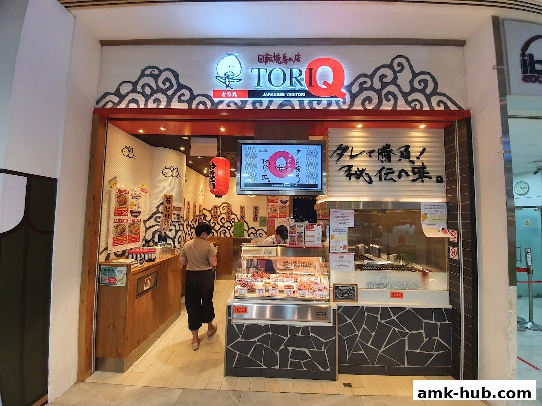The entrance of TORI-Q, a Japanese Yakitori shop, with a display of skewers and a grill.