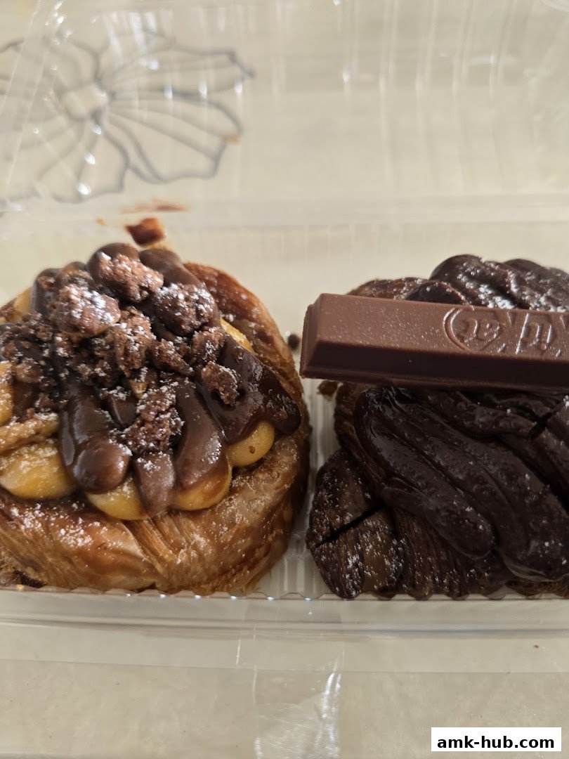 Two delicious pastries, one topped with chocolate and nuts, the other a dark chocolate croissant.