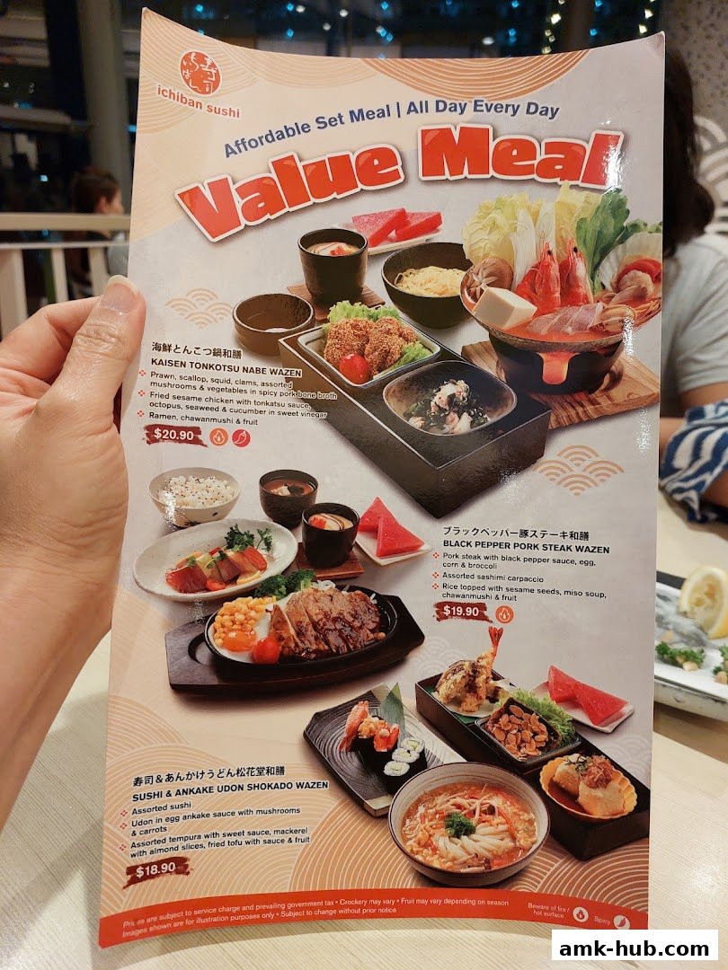 A hand holds a menu from Ichiban Sushi showcasing value set meals with various Japanese dishes.