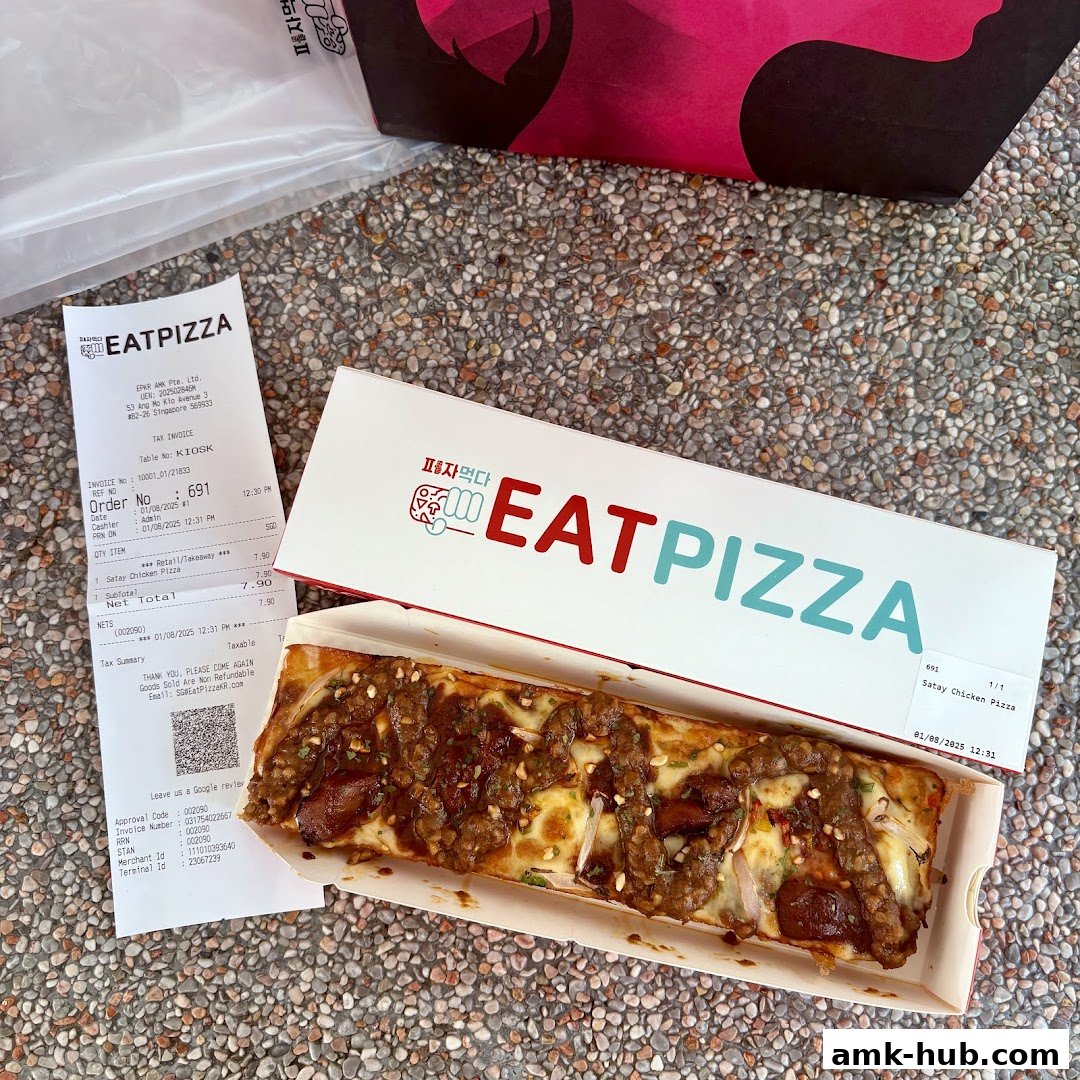 A box of Eat Pizza's Satay Chicken Pizza with a receipt and shopping bag.