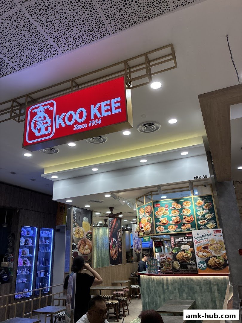 The Koo Kee restaurant interior with a prominent sign and a menu display.