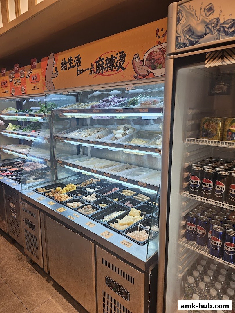 A display of fresh ingredients and beverages at a Mala Tang restaurant.
