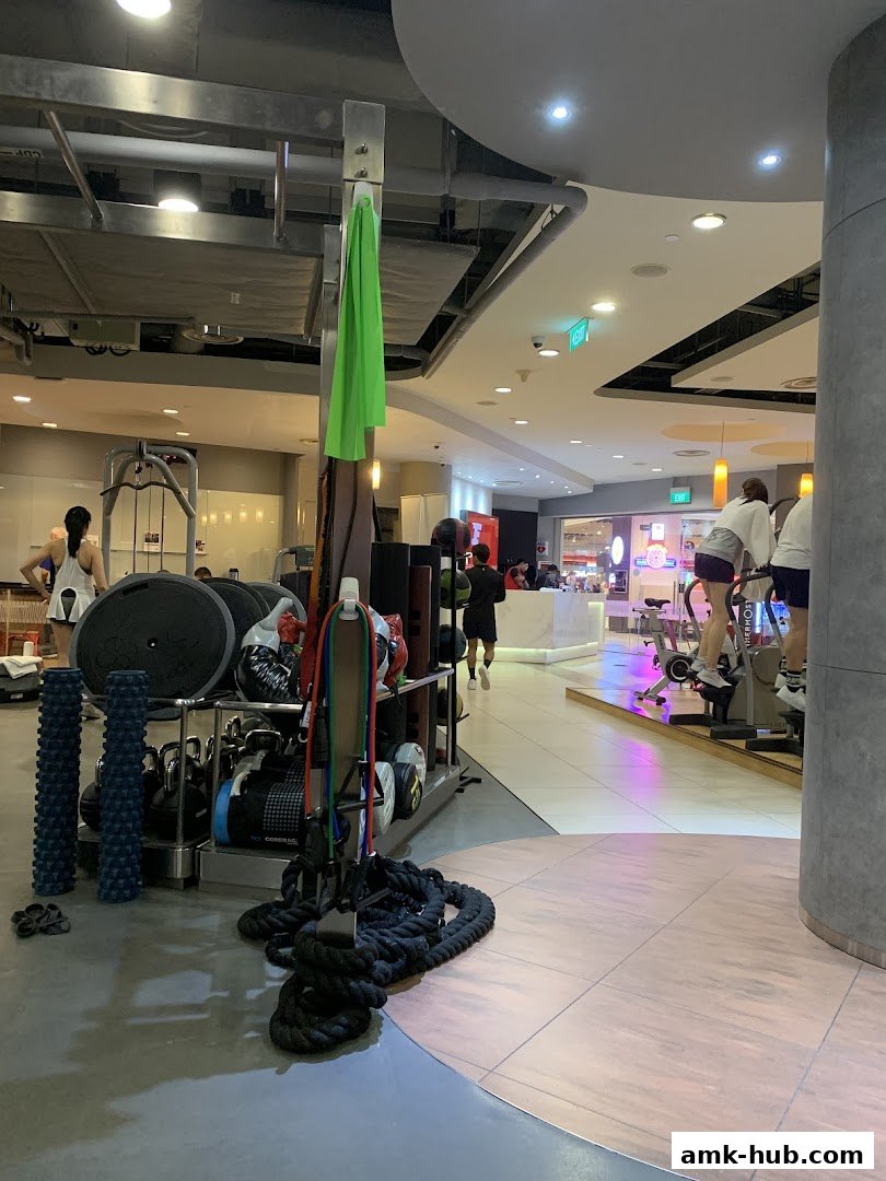 Interior view of a gym with exercise equipment and people working out.