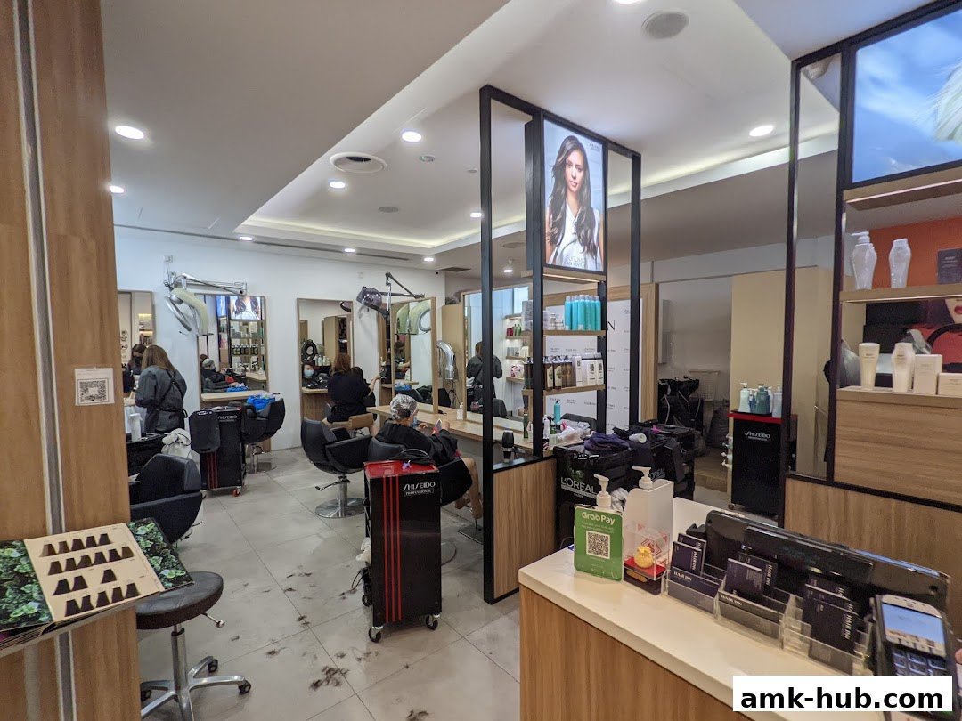 Interior view of a busy hair salon with clients getting haircuts and styling.