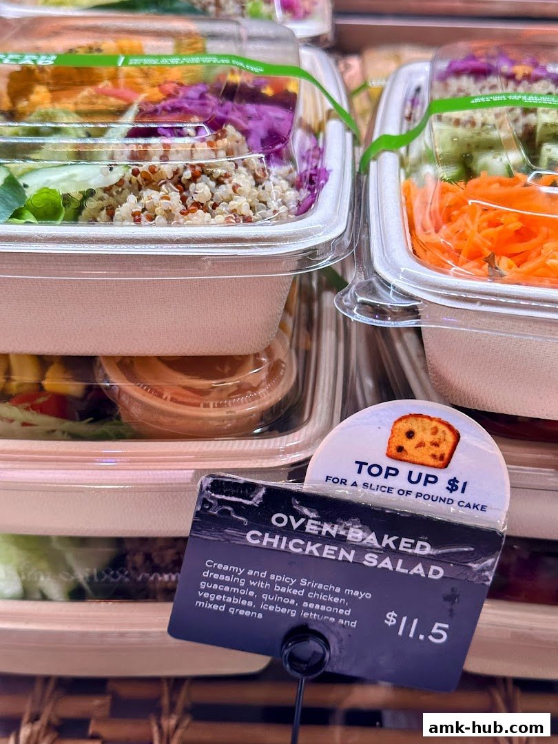 Close-up of a pre-packaged chicken salad with a price tag and a pound cake offer.