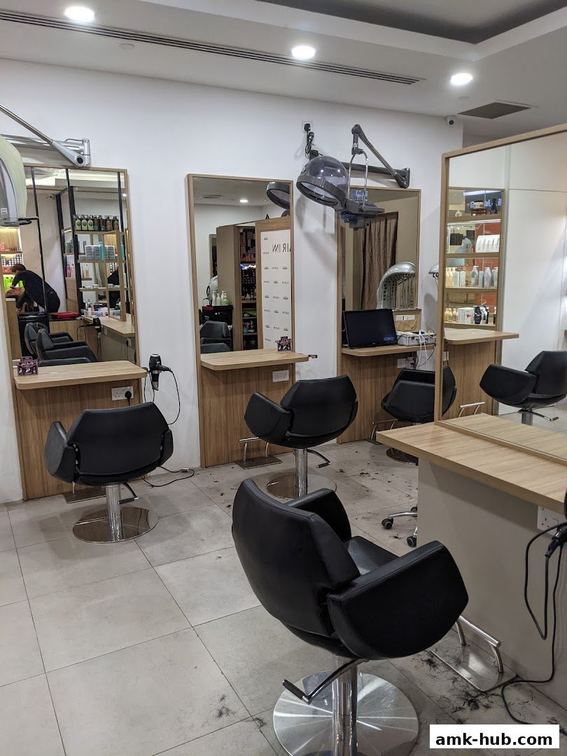 Interior of a modern hair salon with styling chairs, mirrors, and hair dryers.